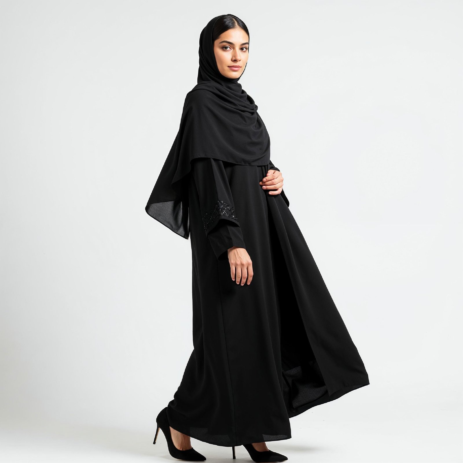 Elegant Muslim Woman Wearing Black Hijab and Abaya in Studio Portrait on Light Background