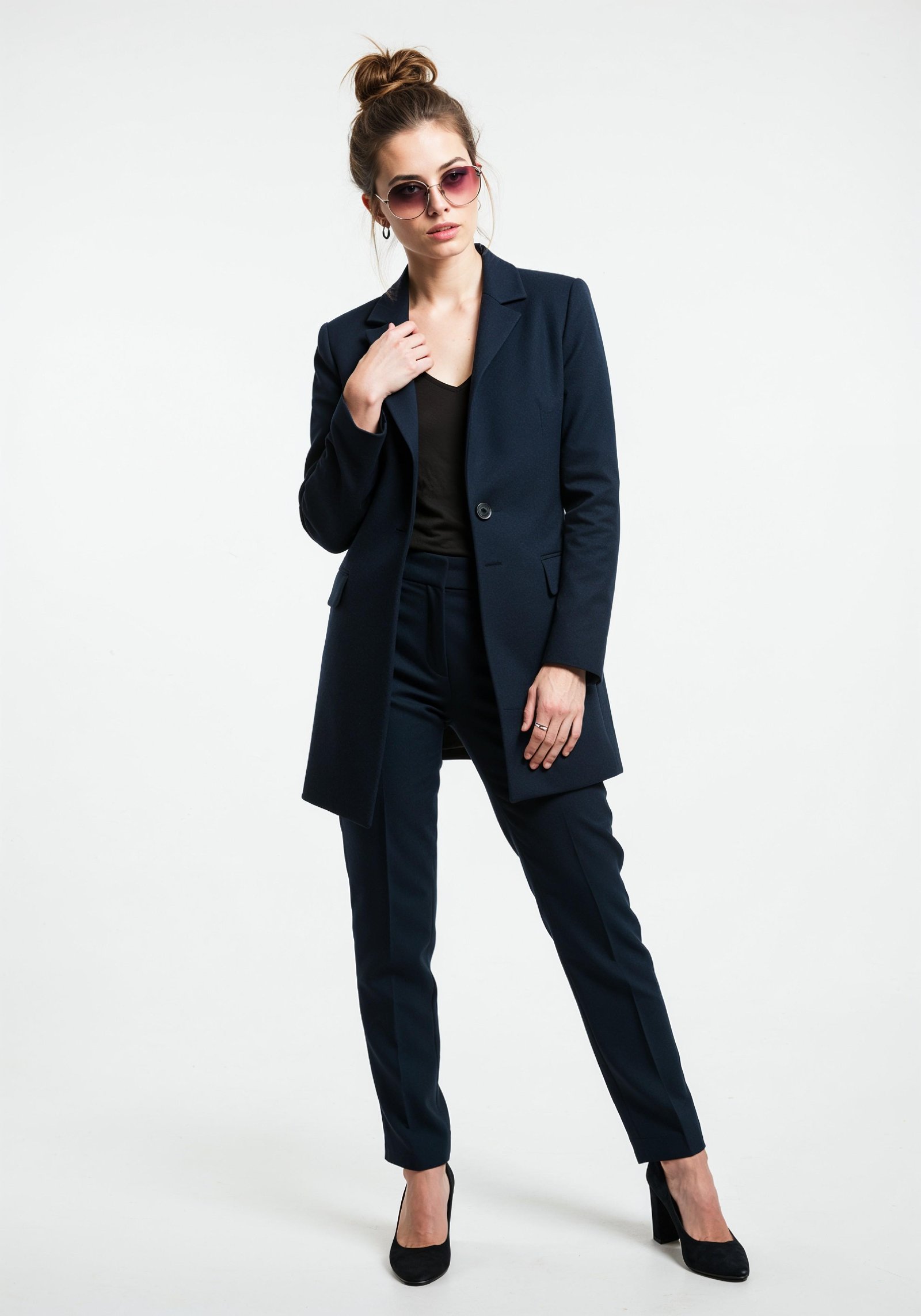 Elegant Young Woman in Coat and Matching Trousers Fashion Portrait